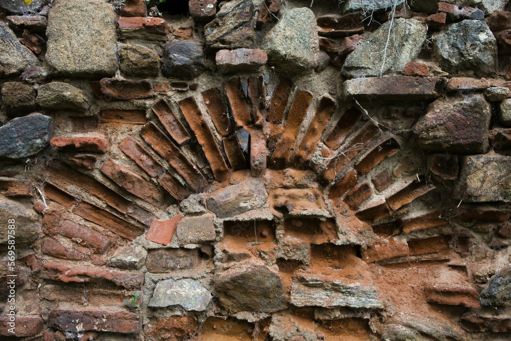 Texture of an old brick wall with an arched structure.