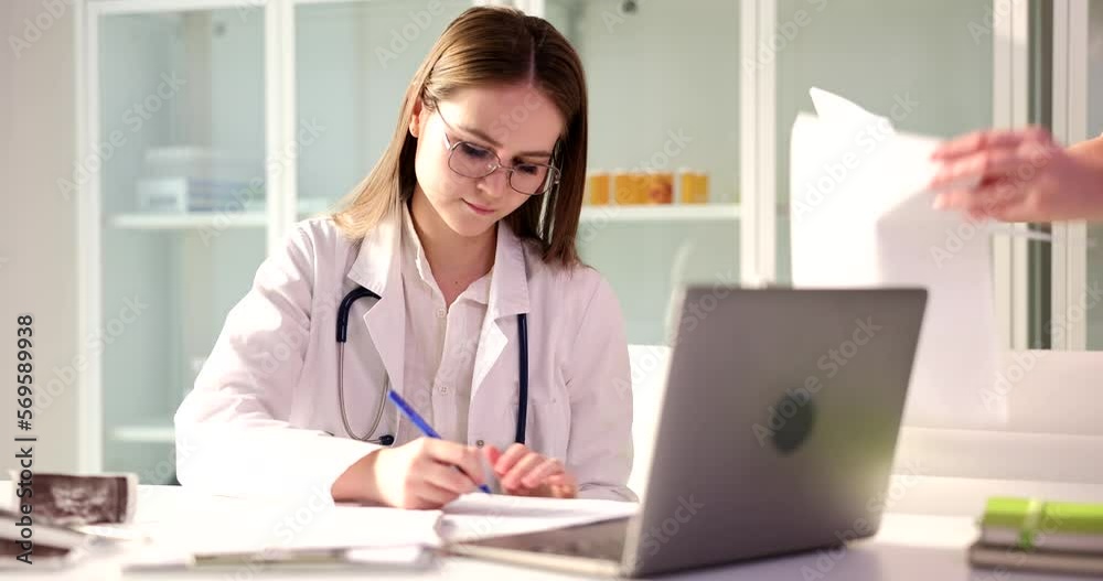 Female practitioner signs documents and hands over to patient Female practitioner signs documents and hands over to patient