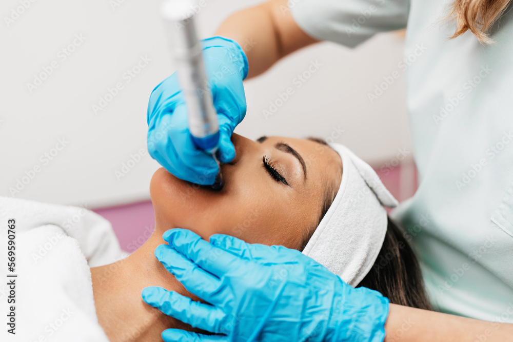Professional cosmetologist making mesotherapy injection with dermapen on face for effective skin rejuvenation. Modern cosmetology spa treatment. Professional cosmetologist making mesotherapy injection with dermapen on face for effective skin rejuvenation. Modern cosmetology spa treatment.