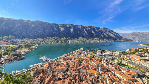 Aerial view of Kotor bay, town and harbour in sunny summer at Adriatic Mediterranean Sea, Montenegro, Balkan, Europe. Fjord winding along coastal towns. Lovcen park. Seen from Kotor fortress wall
