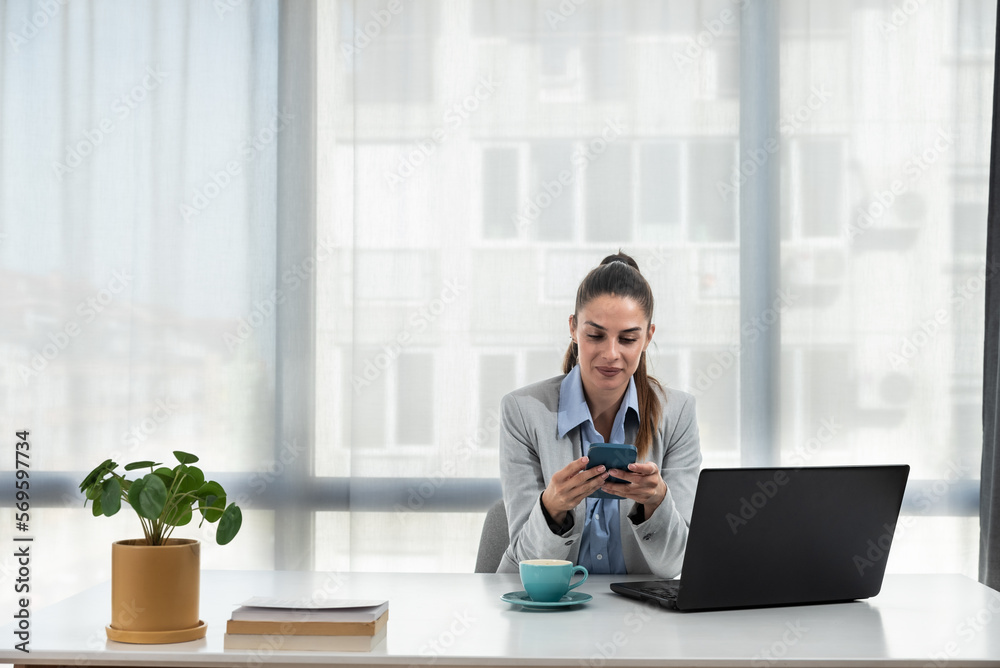 Young happy satisfied successful businesswoman manager and executive sitting in office casually working on laptop computer enjoying working day self-conscious and grateful for success and hard work Young happy satisfied successful businesswoman manager and executive sitting in office casually working on laptop computer enjoying working day self-conscious and grateful for success and hard work