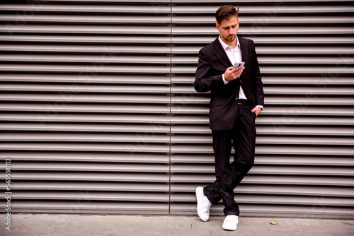 Portrait of a young businessman in a suit look at the phone