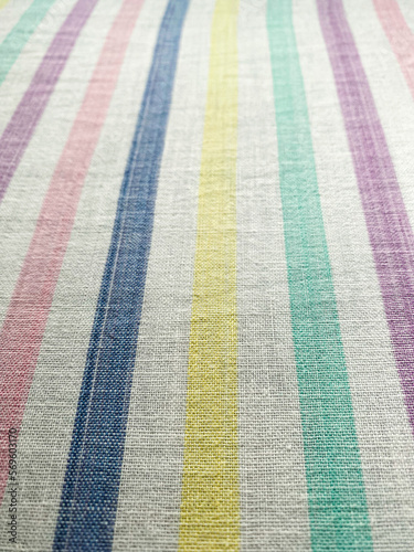 The texture of the fabric. White sheet in multi-colored lines. Cotton, linen, calico. Striped background.