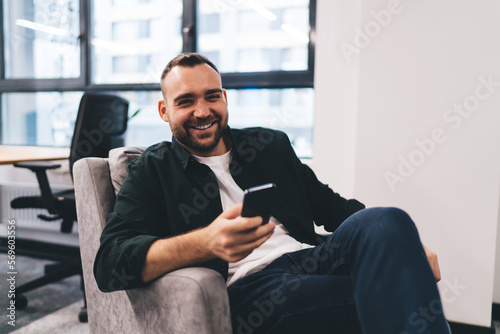 Fototapeta Naklejka Na Ścianę i Meble -  Cheerful businessman smiling while chatting on cellphone