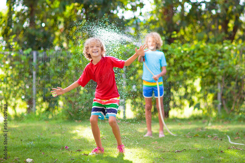 Kids play with water sprinkle hose. Summer garden Kids play with water sprinkle hose. Summer garden