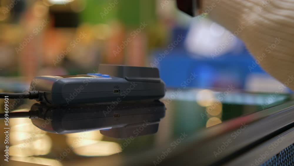 Close up customer paying with an NFC contactless smartwatch with a card machine. Close up customer paying with an NFC contactless smartwatch with a card machine.
