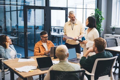 Group of diverse colleagues discussing project in office