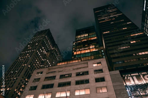 Old city building office at night. Low angle view of skyscrapers. Looking up perspective. Bottom view of modern skyscrapers in a business district. Cityscape at night.	
