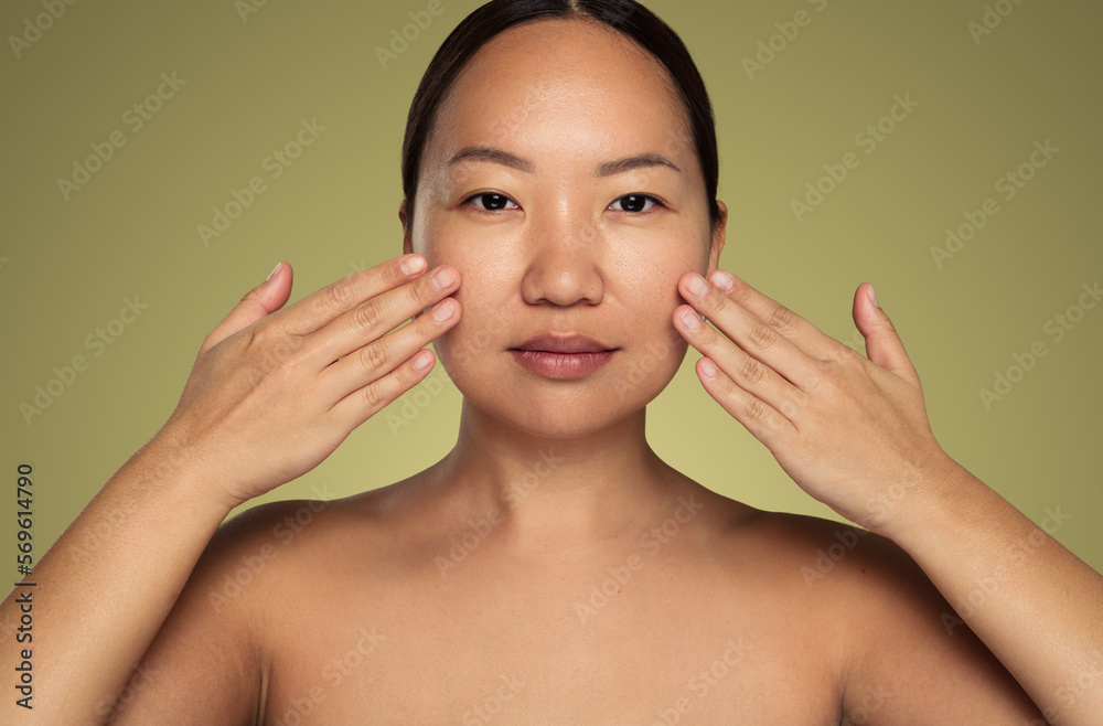 Graceful ethnic lady touching face during skincare procedure