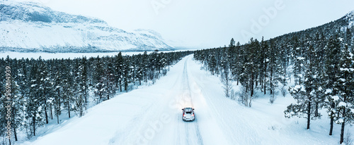 Overhead car-view driving on icy road crossing a forest covered with snow, Stora Sjofallet, Norrbotten County, Lapland, Sweden, Scandinavia, Europe