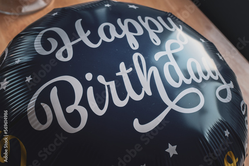 An inflated blue balloon spells Happy Birthday.