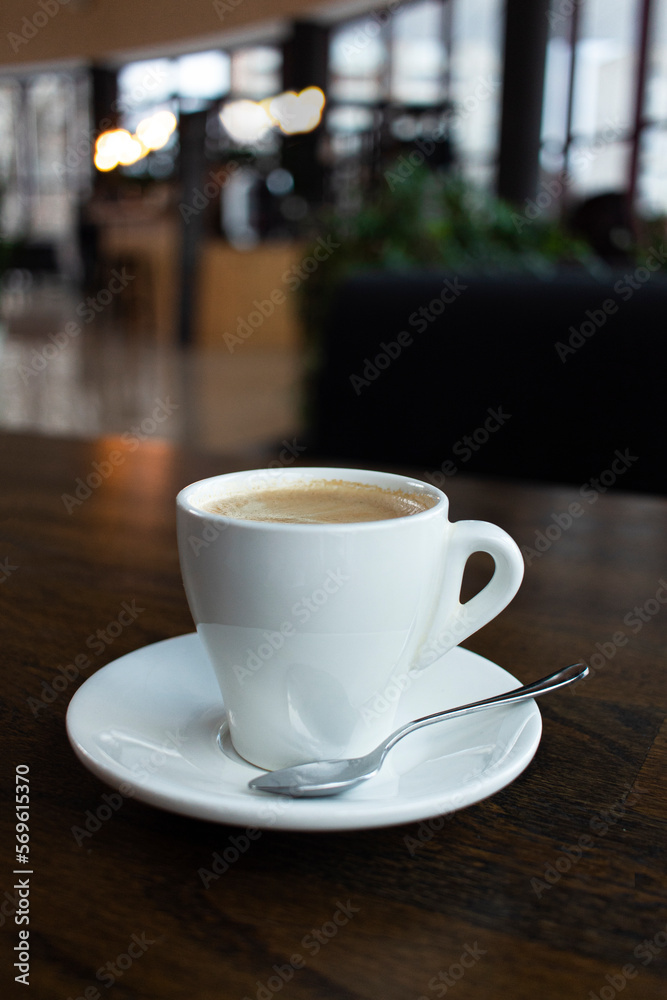 Close up white cup of coffee latte on wood table in cafe Close up white cup of coffee latte on wood table in cafe