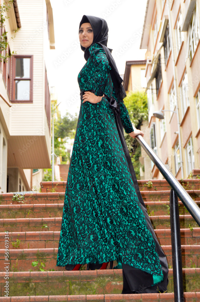 Modern stylish trendy beautiful Muslim Caucasian Turkish model woman in black hijab and long black green dress