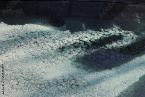 Słoneczny poranek topi lód na szybie samochodu. Wiosna. 