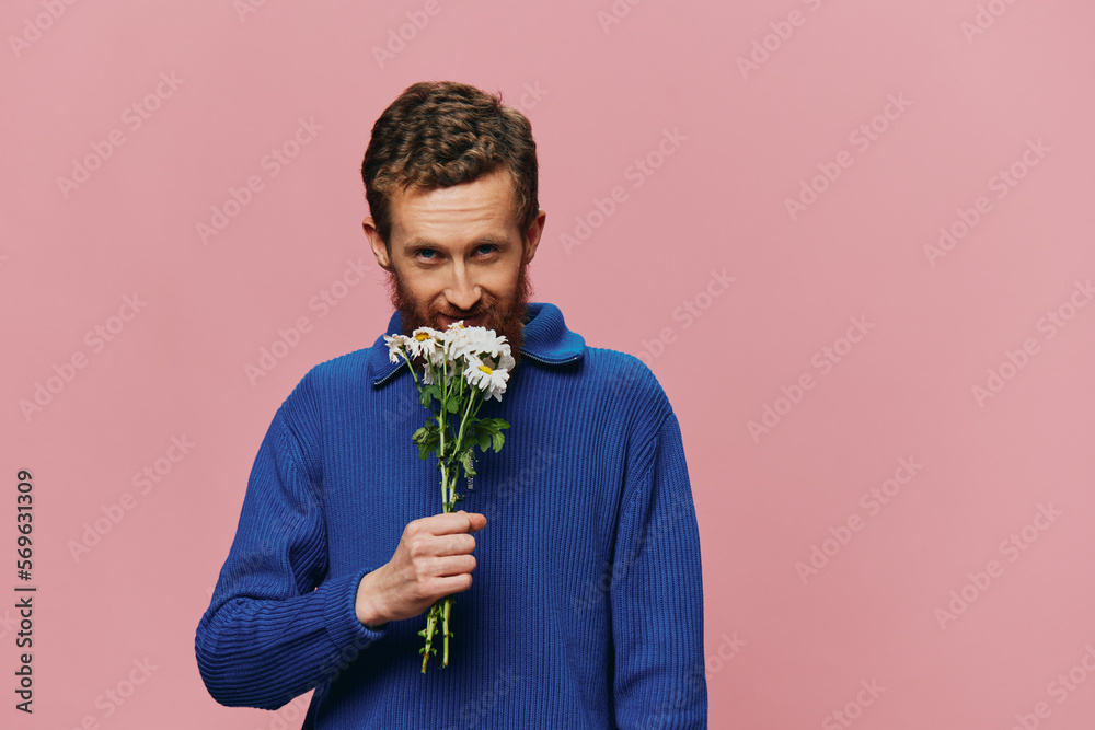 Portrait of a funny man smiling with a bouquet of flowers daisies on pink isolated background, copy place. Holiday concept and congratulations, Valentine's Day, Women's Day. Portrait of a funny man smiling with a bouquet of flowers daisies on pink isolated background, copy place. Holiday concept and congratulations, Valentine's Day, Women's Day.