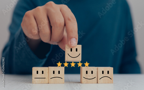 Satisfaction evaluation and service concept, hand picked wooden blocks, happy face up to the top, five stars