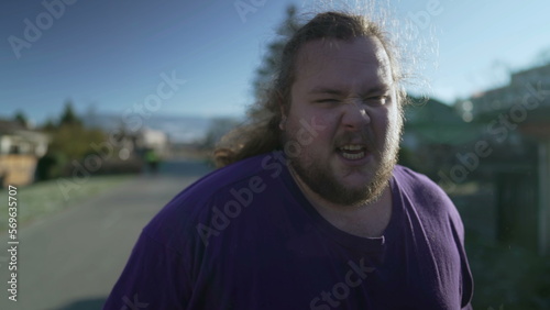 Portrait of an upset angry person walking outside feeling regret for past mistake. Tracking shot of a frustrated person reaction negatively to memory