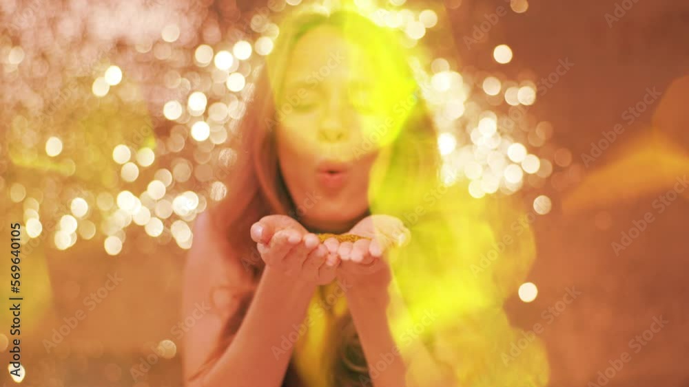 Woman blowing glittering confetti