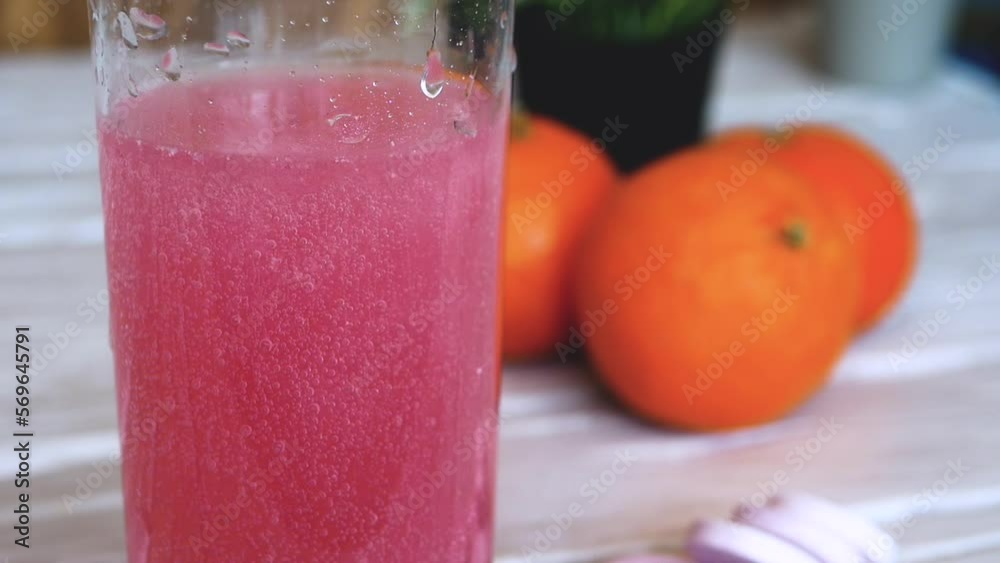 Close-up Vitamin pop with water. The concept of drinking vitamin C in tablets. Fruit juice or ...