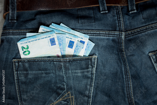 money 20 euros bills in backpocket of jeans denim pants, carry concept