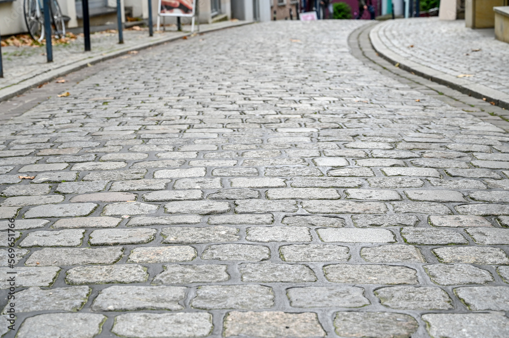 Cobblestone road pattern. Bricks on ground. Cobblestone texture on the street, close up. Brick floor tiles in city street.