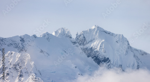 Fototapeta Naklejka Na Ścianę i Meble -  Tantalus Range covered in Snow and Clouds during Winter Season. Near Whistler and Squamish, British Columbia, Canada. Nature Background