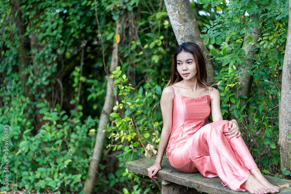 Pink-clad young woman finds solace on old wooden chair amidst tranquil nature Pink-clad young woman finds solace on old wooden chair amidst tranquil nature
