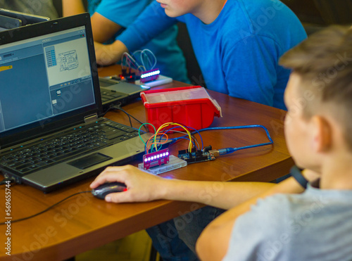 boys in the classroom for programming and robotics. The laptop with the program is on the table, the child controls the mouse. the controller is connected to the laptop