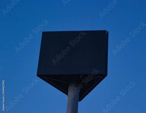 big advertising sign against the blue sky. Three-sided billboard for logos