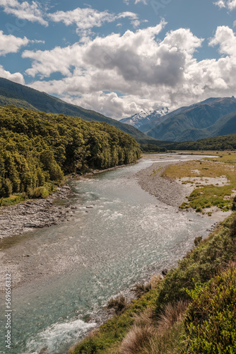 The Makarora river in the Otago region of New Zealand flowing towards Wanaka Lake with snow capped mountains in the distance