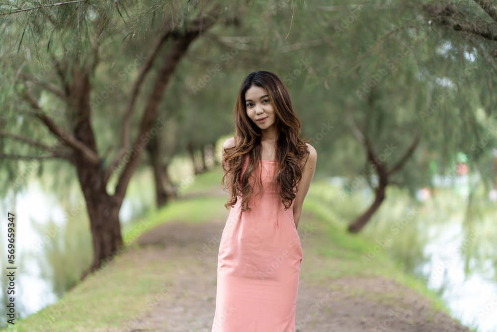 Stylish woman embraces comfort in pink dress against bokeh park background Stylish woman embraces comfort in pink dress against bokeh park background
