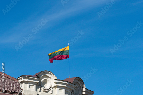 Lithuanian flag on top of a building against blue sky