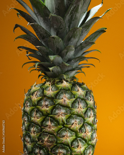 A close-up of a pineapple on a yellow background