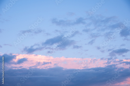 Abstract pink sunset sky and dark blue clouds background with motion blur. Bright pink-blue sky