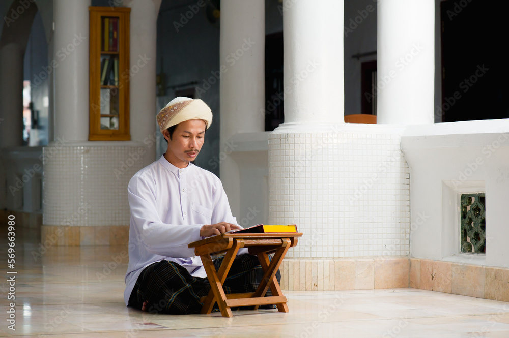 Religious muslim islam man in white session sit on the floor and read