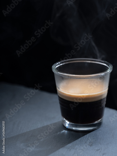 Espresso coffee on a transparent glass, on a black background