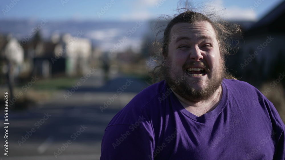 Fototapeta premium Person celebrating success feeling ecstatic standing outside. Happy emotion close up face. Tracking shot of One overweight joful male person. Triumph concept