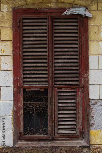 close-up of a beautiful black forged fence on a window with shutters in a old house