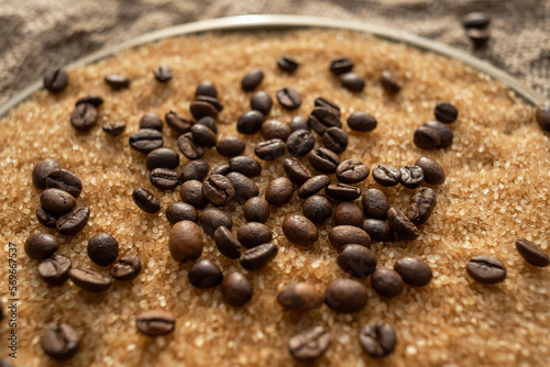 Coffee beans on brown sugar cane  lying on a bronze plate  against a background of coarse burlap. Background picture in brown tones
