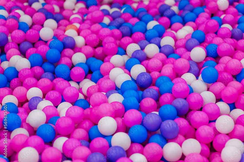 Background, texture of colored, multi-colored round plastic small balls on the playground for children's games. Photography, top view, copy space, childhood concept, macro, wallpaper.