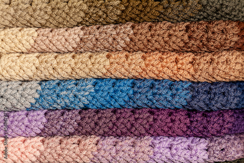 Stacked multi-colored crocheted garment items.
