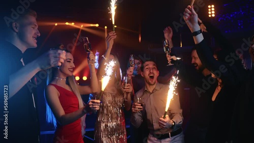 Overjoyed group of friends toasting champagne sparkle lights celebrate holiday at nightclub party