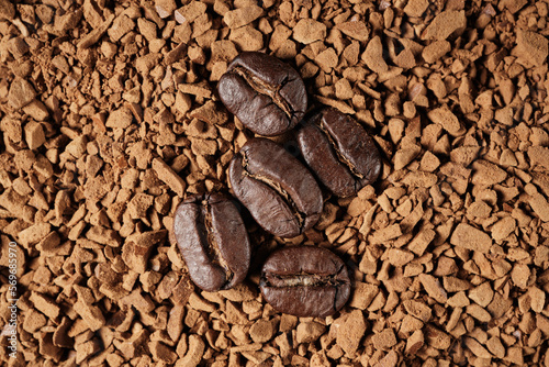 Close-up of roasted coffee beans on the background of granular instant. top view