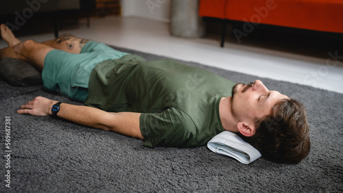One modern caucasian man adult male practice restorative yoga at home