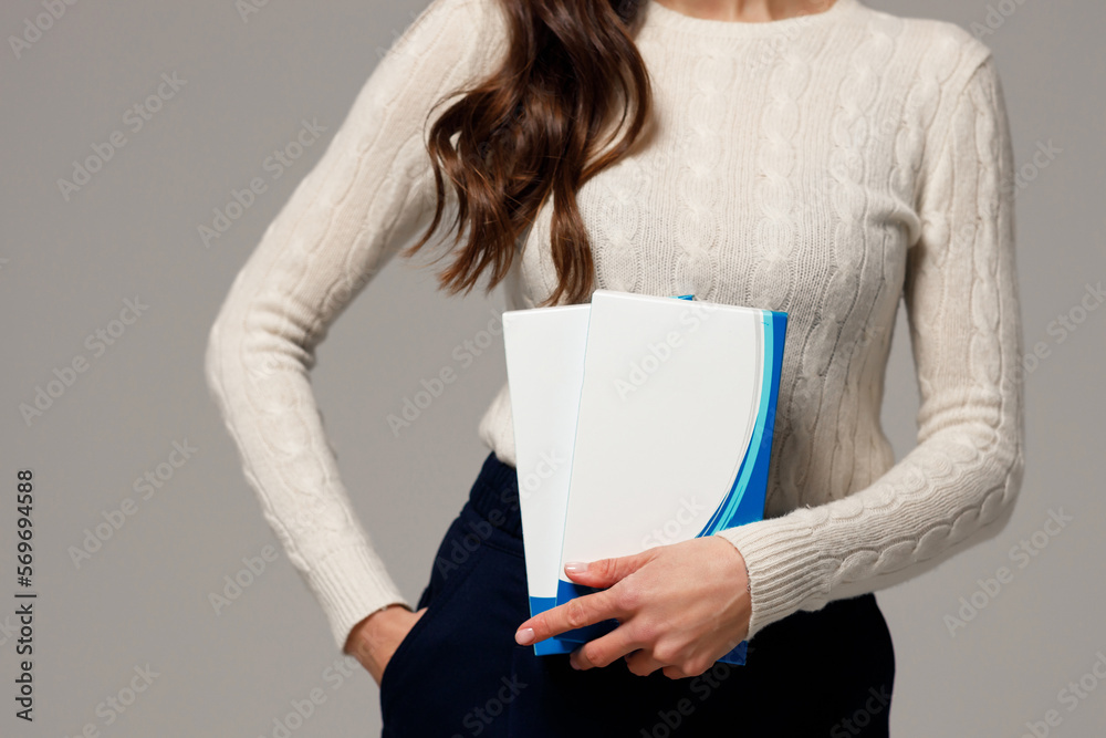 Φωτογραφία Stylish young girl with long hair and glowing skin is holding cosmetic products in her hands and smiling
