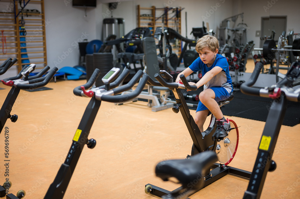 Young boy exercises in the professional gym