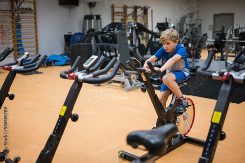 Obraz na płótnie Young boy exercises in the professional gym w salonie