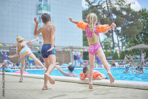 Happy little children listen to music, dance, sing songs, have fun in the summer pool, relax by the sea. Morning workout exercise.