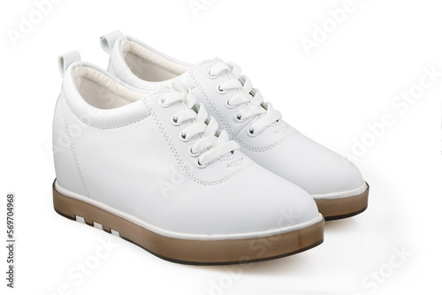 White women's sports shoes made of leather isolated on a white background. Minimal concept of beauty and sports. The white women's sneakers isolated on white.