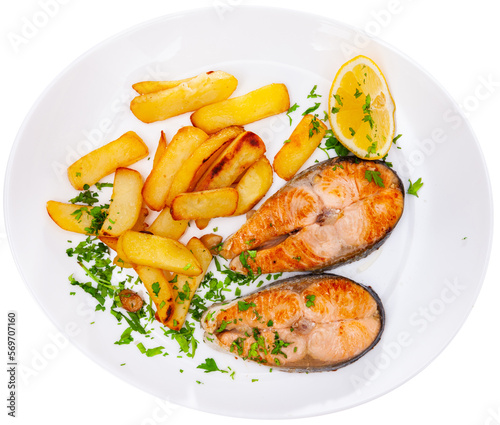 Grilled salmon steak served on plate with fried potato. Garnished fish ready-to-eat. Isolated over white background